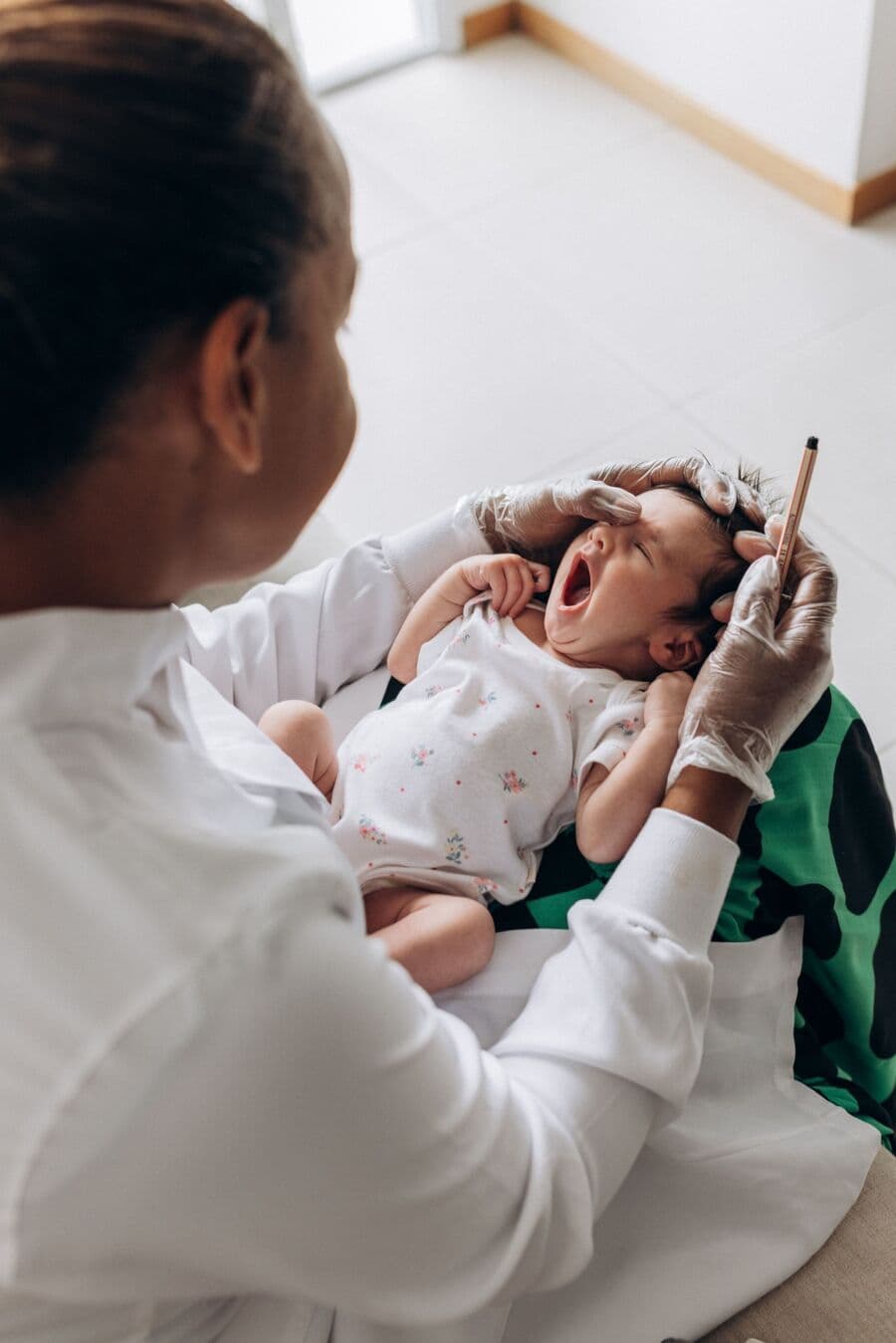 Médica sosteniendo a un recién nacido durante una exploración